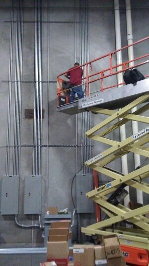 Expert on scissors lift making an electrical conduit and wiring installation